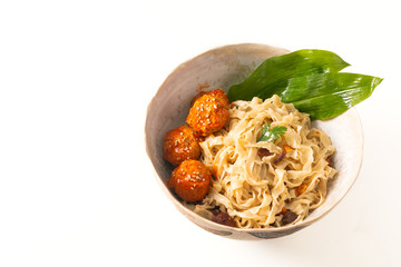 Asian Food concept homemade oriental egg noodles and spicy meatballs in ceramic bowl on white background