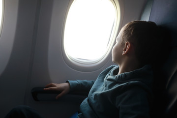 Boy looks out window of plane