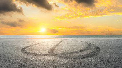 Fototapeta premium Asphalt race track ground and river with beautiful clouds at sunset