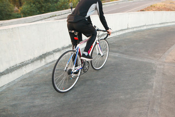 Fototapeta na wymiar Athlete cyclist in sportswear rides around the city on a white bike. Traveling around the city on a bicycle. Copyspace