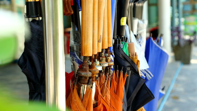 Close up group of Many umbrellas hung on hangers 