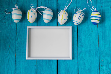 Colorful Easter Eggs arranged to one side on a blue background.