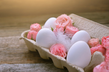 beautiful Easter still life. cute eggs in  cardboard box and rose flowers. decoration of Easter food. spring season. happy Easter spring holiday concept.