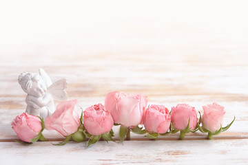 beautiful still life with roses and toy fairy on light background. spring season. celebration concept with Valentine's day or Mothers Day, birthday. 