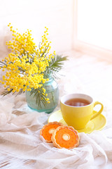 Cup of tea, cookies and  bouquet of Mimosa. spring still life. Spring background. composition for mother's Day, March 8, Easter. selective focus