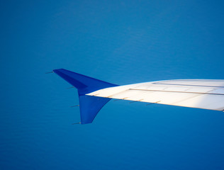 Passenger plane wing over the ocean.