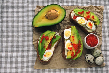 Healthy avocado toast with quail eggs and red caviar. Keto diet. Keto toasts