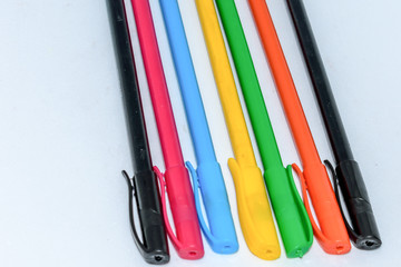 Close-up selection of Multi Colored pencils crayons, close together in a row arrangement in white background, flat lay. Horizontal geometric art design. Top View. Back to school creativity concept.