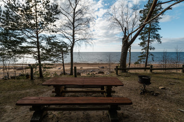 Fototapeta na wymiar Beautiful distant picnic and camping spot near a Baltic sea in a pine forest with a boulder beach in the background - Veczemju Klintis, Latvia, April, 2019