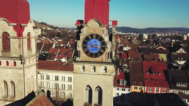 Drone flight with aerial view above church in old town of Winterthur in Switzerland. Tower and building roofs from above. Dynamic shots of European town.