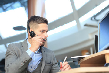 Smiling friendly handsome young male call centre operator.