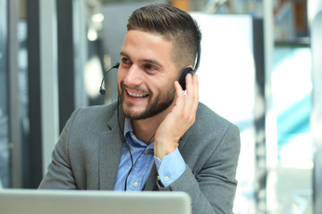 Smiling friendly handsome young male call centre operator.
