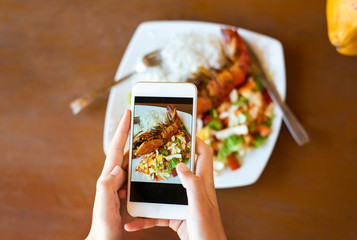 Girl taking photo of seafood in a restaurant