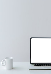 Mockup blank screen laptop and whtie mug on white table. - obrazy, fototapety, plakaty