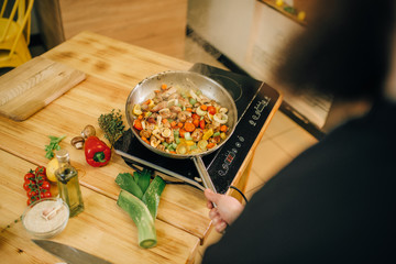 Bearded chef cooking meat with vetables