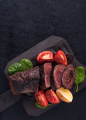 A juicy beef steak of weak roast with blood on a wooden kitchen Board. The view from the top.  Copy space. Free space for text