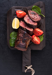 A juicy beef steak of weak roast with blood on a wooden kitchen Board. The view from the top.  Copy space. Free space for text