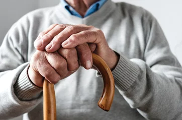 Foto op Canvas Hands of an elderly man resting on a walking cane © sergign