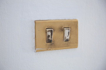 The old and dirty light switch on wall