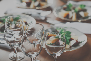 Set of wineglasses and plates with salad in the beautifull light