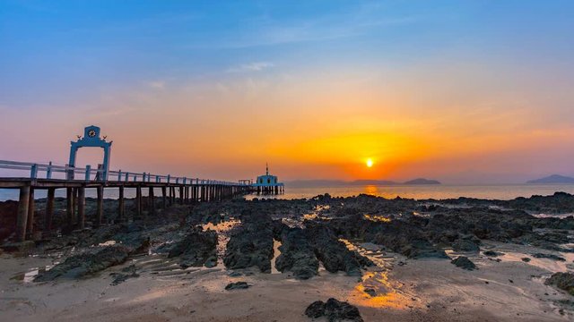 timelapse sunrise above Buddha on the pier at Phayam temple in Phayam island..landmark at Hin Kao gulf in Phayam island Ranong Province Thailand