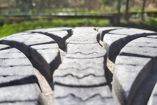 Close-up winter tire tread. Textured tire tread on green and bokeh background.