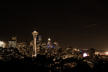 Night view of the Seattle skyline with the Space Needle and other iconic buildings in the background.