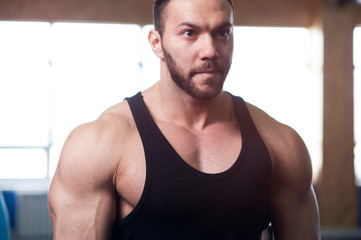 Obraz premium Portrait of Young Strong Man Training in Gym