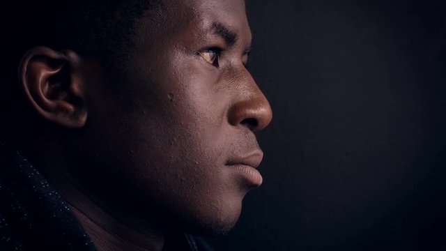 pensive young black african man thinking in the dark-profile