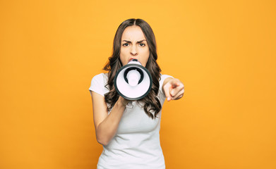 Healthy yells. An angry girl with a speaking-trumpet in her one hand is screaming on somebody and pointing out right on this person.