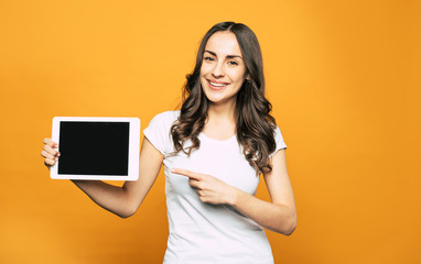 This is what you need! Modern white colored tablet PC with great properties in the hand of gorgeous young girl in basic white T-shirt and brilliant smile all over her face.