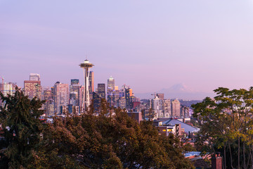 Sunset over the skyline of the city of Seattle and the profile of Mount Rainier in the background.