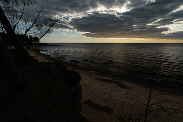 Obraz premium Moss sand and moody cloudy sky on the Baltic Sea close to sunset - Veczemju Klintis, Latvia - April 13, 2019