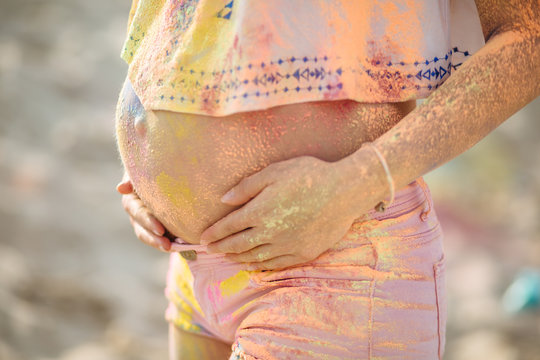 The girl in the colors of holi. Pregnant girl on holi celebration.