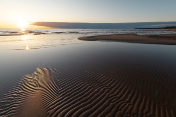 Red vivid sunset at the Baltic Sea with mirror like water - Ribbed sand and waves - Veczemju...
