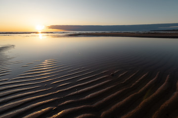 Red vivid sunset at the Baltic Sea with mirror like water - Ribbed sand and waves - Veczemju...