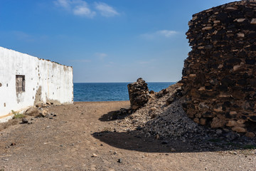 Old buildings with beach at the sea on fuerteventura of canary islands in spain