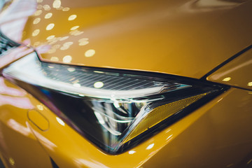 Car detailing series: Clean headlights of yellow sports car.