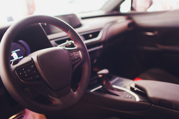 Dark luxury car Interior - steering wheel, shift lever and dashboard.