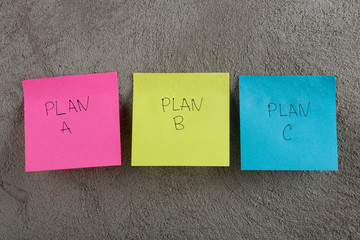 Business choice - Plan a, plan b or plan c on colorful office stickers on concrete wall