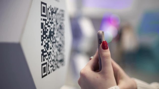 Scanning QR code with smart phone. The man reads the bar code using the application on the smartphone.