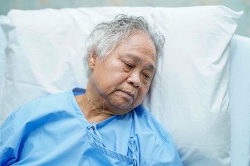 Asian senior or elderly old lady woman patient smile bright face with strong health while lying on bed in nursing hospital ward : healthy strong medical concept 