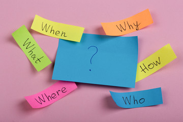 Questions - Why? What? Where? When? Why? How? on colorful stickers on pink backround