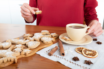 Unrecognizable woman having hot chocolate with ginger cookies for dessert