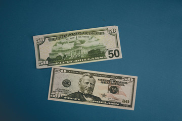 Pack of fifty dollars banknotes isolated on blue background