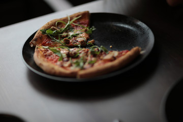 The tasty pizza on the beautifull plate in cafe
