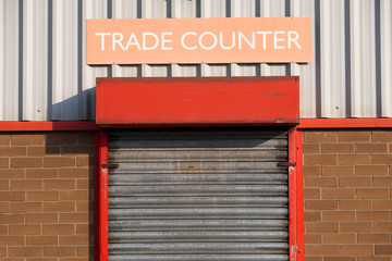 Trade counter sign above roller shutter door entrance business merchants in industrial estate