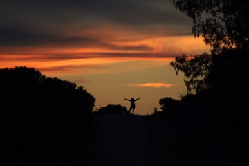 Happy woman silhouette at sunset