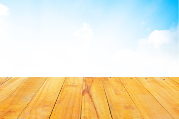 Old Wooden table with blue sky white cloud background.