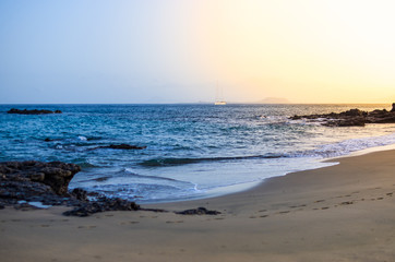 Fototapeta na wymiar Image of a beach with a sailboat crossing the horizon